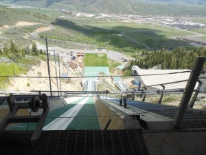 View from top of ski jump, skis go in white tracks on jump