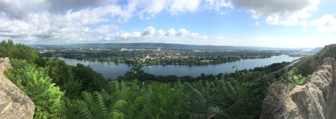Panoramic view of Winona MN. Wisconsin bluffs in background, then thin blue ribbon is Mississippi River, then City of Winona, then Winona lakes and finally nearest to you the Garvin Heights Bluffs